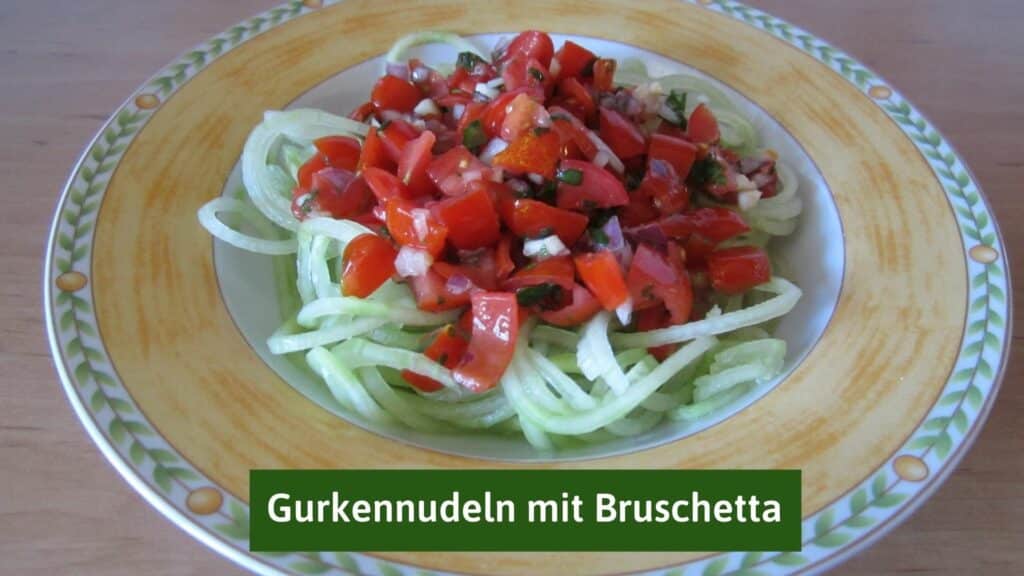 Cucumber pasta with tomato bruschetta on a terracotta colored plate