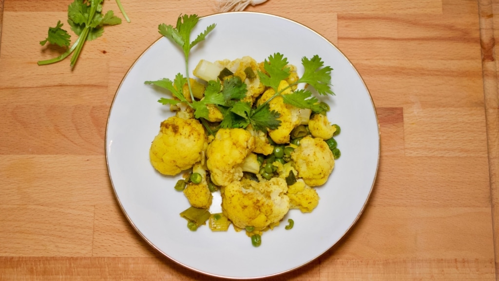 Piatto di cavolfiore e piselli al curry