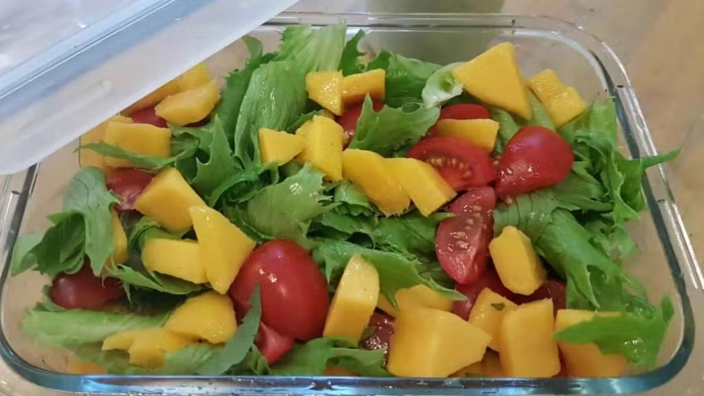 Cuenco de cristal con ensalada de mango y tomate